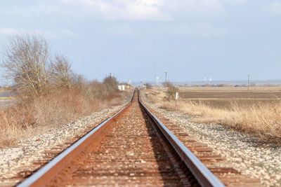 Surface level of railroad tracks against sky