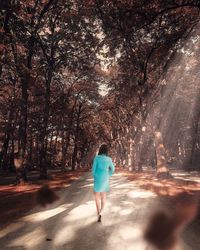 Rear view of woman walking on road
