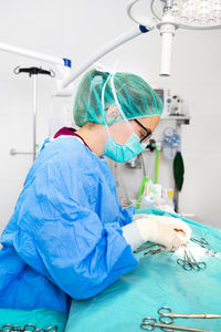 Side view of surgeon performing surgery at hospital