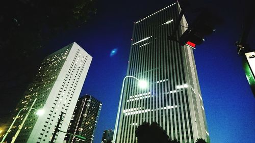 Low angle view of illuminated skyscraper against sky at night