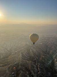 Hot air balloon flying over landscape against sky