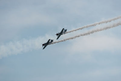 Low angle view of airshow against sky