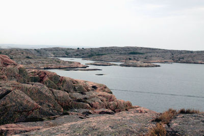 Scenic view of sea and mountains against clear sky