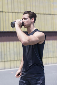 Confident young man exercising during sunny day