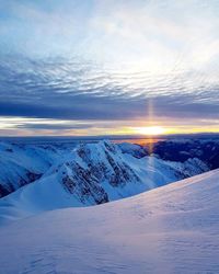 Scenic view of snowcapped landscape against sky during sunset