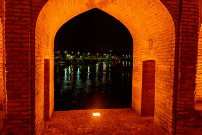 Reflection of illuminated building in water at night