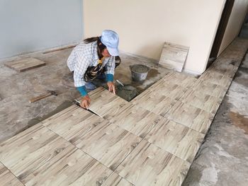 Full length of man working on wooden floor at home