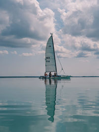 Sailboat sailing on sea against sky