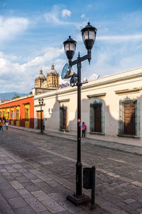 Street light on sidewalk against buildings in city