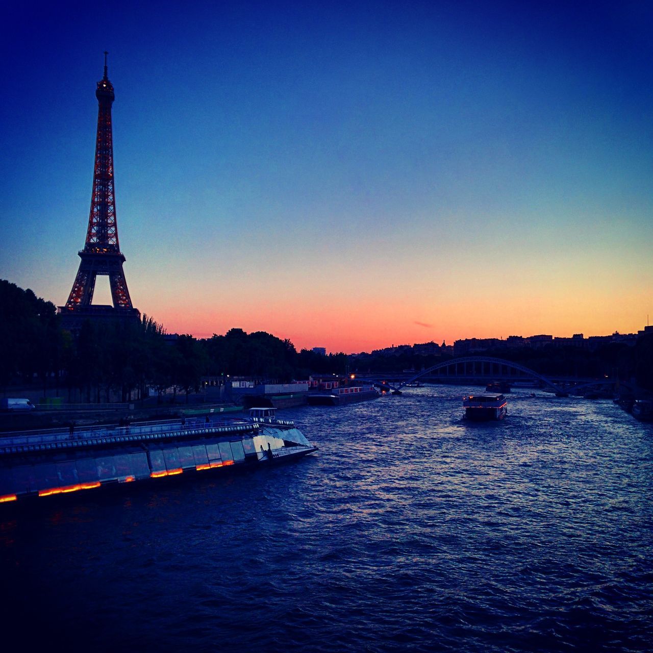 architecture, built structure, water, clear sky, sunset, transportation, waterfront, copy space, international landmark, bridge - man made structure, river, famous place, travel destinations, engineering, travel, blue, connection, tourism, building exterior, illuminated