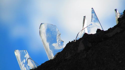 Low angle view of snowcapped mountain against blue sky