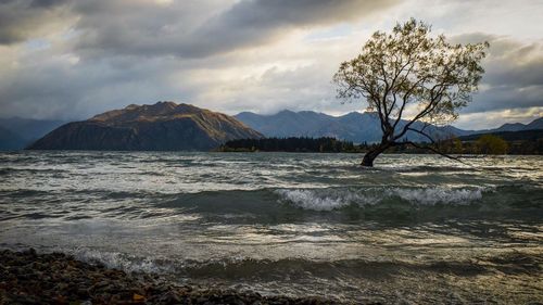 View of calm sea against mountain range