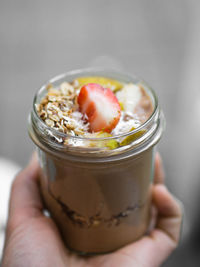 Close-up of hand holding ice cream in jar