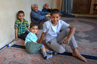 Portrait of happy friends sitting on floor