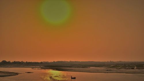 Scenic view of land against clear sky during sunset