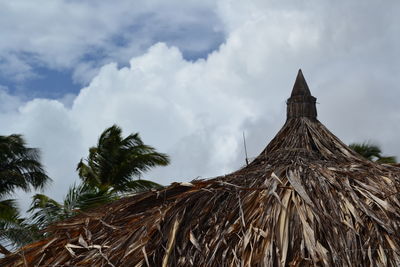 Low angle view of thatched roof against sky