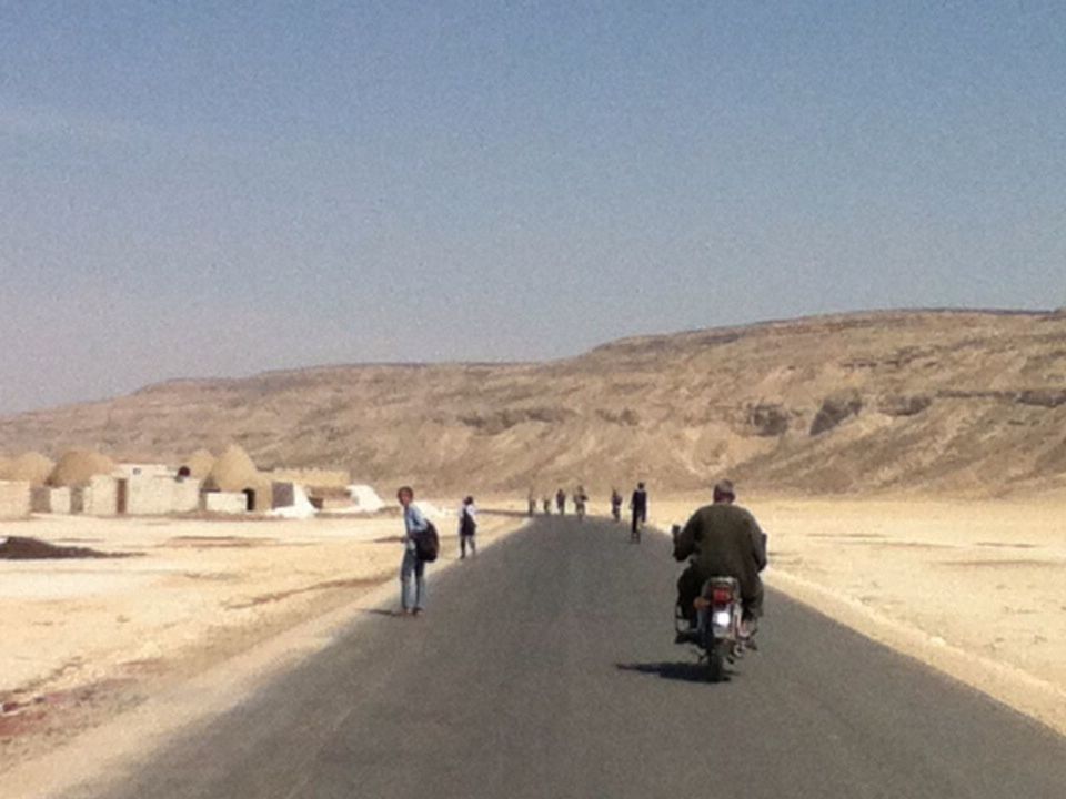 MEN IN DESERT AGAINST SKY