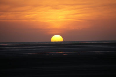 Scenic view of sea against orange sky