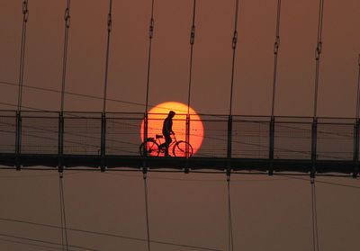 Low angle view of illuminated railing against sky during sunset