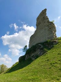 Low angle view of rocks on field against sky