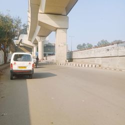 Road by bridge against sky in city