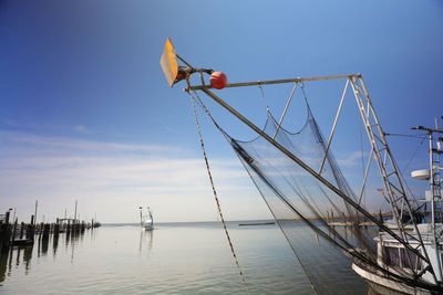 Low angle view of fishing net in sea against sky