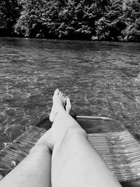 Low section of woman relaxing in swimming pool