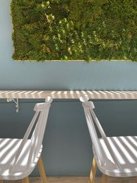 Empty chairs by swimming pool against sky