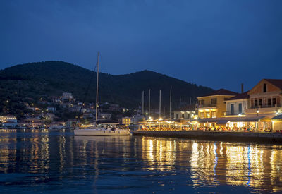 River by illuminated buildings against clear sky at night