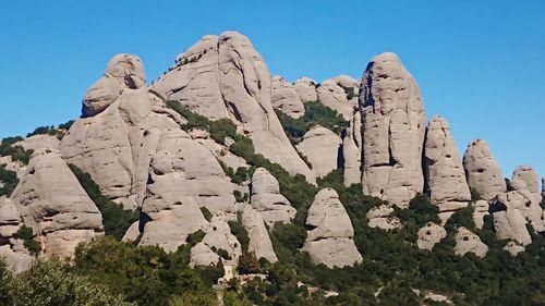 Low angle view of rocks on mountain against sky
