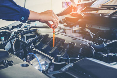 Cropped hands of mechanic repairing car in garage