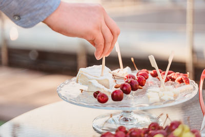 Cropped image of hand holding ice cream on table