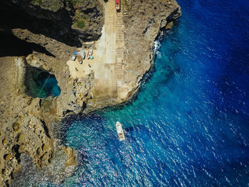 Aerial view of rock formation and boat in sea