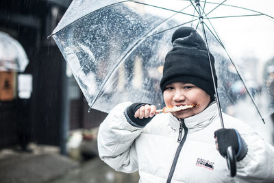 Portrait of boy holding ice cream in snow