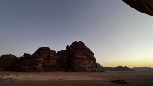 Ruins of rock formation against clear sky during sunset