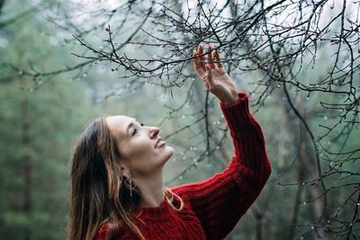 Improving mental wellbeing, relax and reduce stress. young woman in red sweater touching water