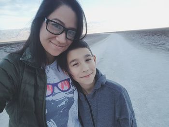 Portrait of happy mother with daughter against sky