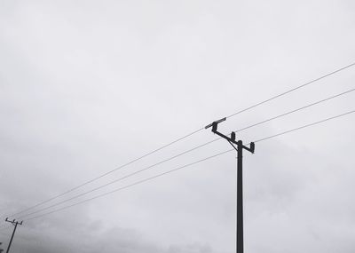 Low angle view of power lines against sky