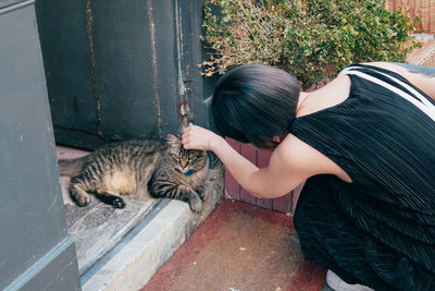 High angle view of cat by woman wearing hat