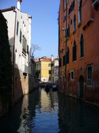 Canal amidst buildings against sky