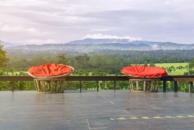 Scenic view of red chairs against sky