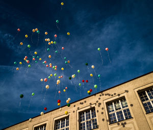 Low angle view of illuminated buildings against sky at night