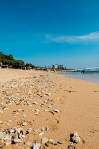 Scenic view of beach against blue sky