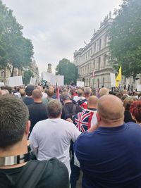 Rear view of people walking on street in city