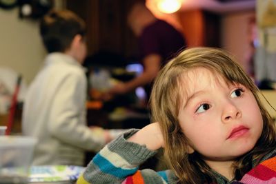 Cute girl looking away while waiting at restaurant