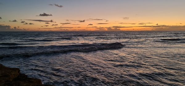 Scenic view of beach against sky during sunset