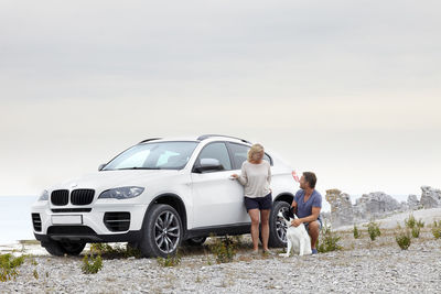 Couple with dog near car