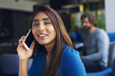 Portrait of smiling young woman talking on mobile phone