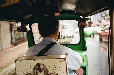 Rear view of man sitting in car