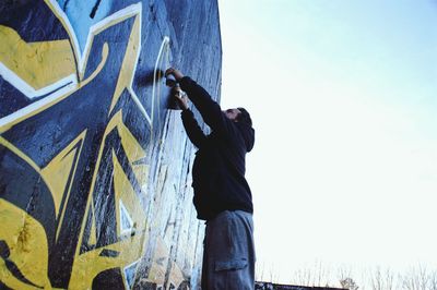 Low angle view of man standing against sky